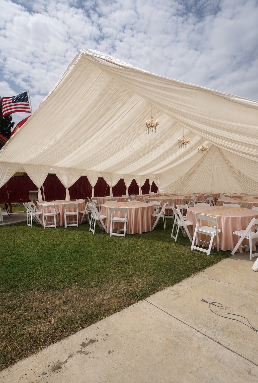 Ivory 30×40 draped canopy with three chandeliers and reception seating