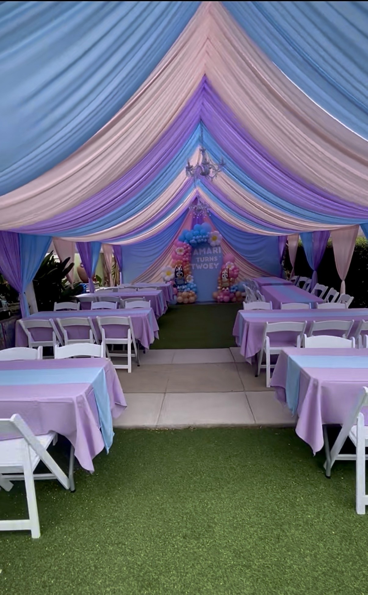 Blue, pink, and purple canopy draping with coordinated linens for a birthday celebration